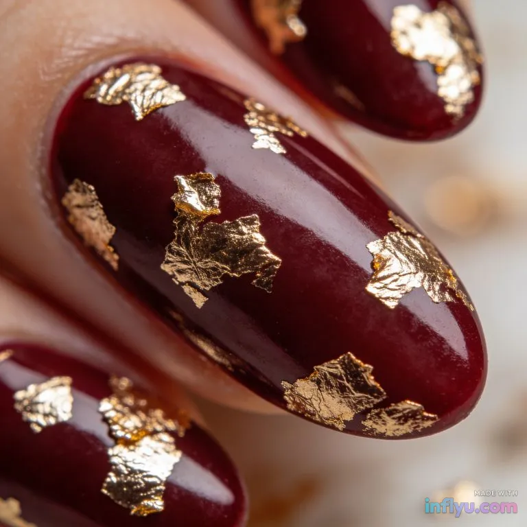 Burgundy almond nails with gold leaf accents, AI image
