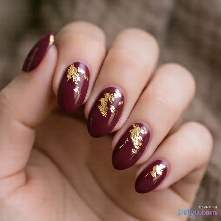 Burgundy almond nails with gold leaf accents, AI image