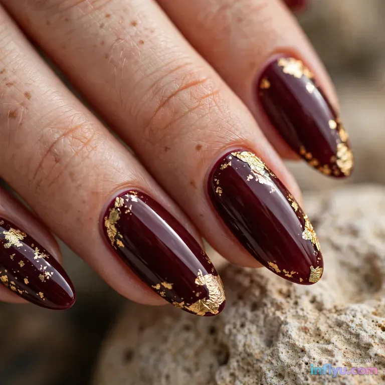 Burgundy almond nails with gold leaf accents, AI image